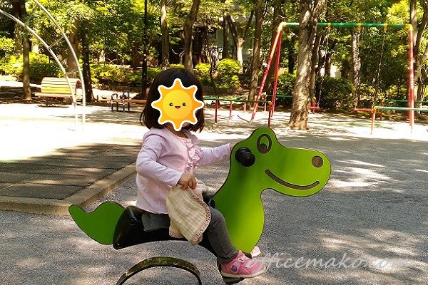 女の子が公園で遊具に乗っている画像