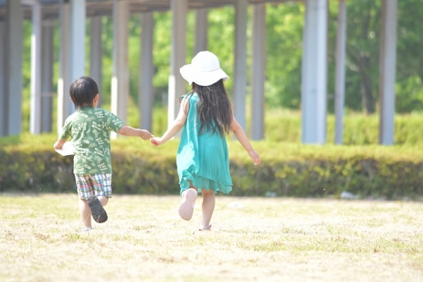 男の子と女の子が手を繋いで走っている画像
